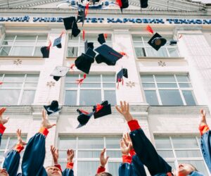 Studierende schmeißen ihre Abschlusshüte in die Luft