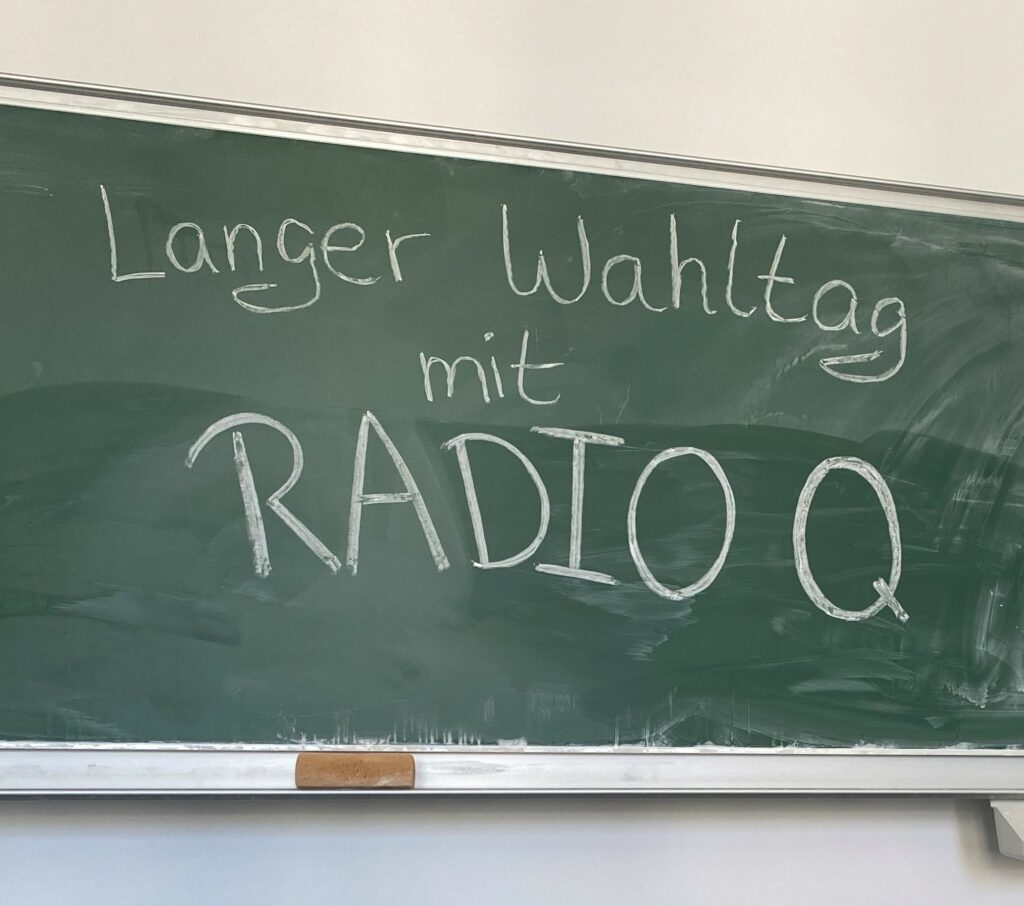 Tafel mit der Aufschrift "Langer Wahltag mir Radio Q"