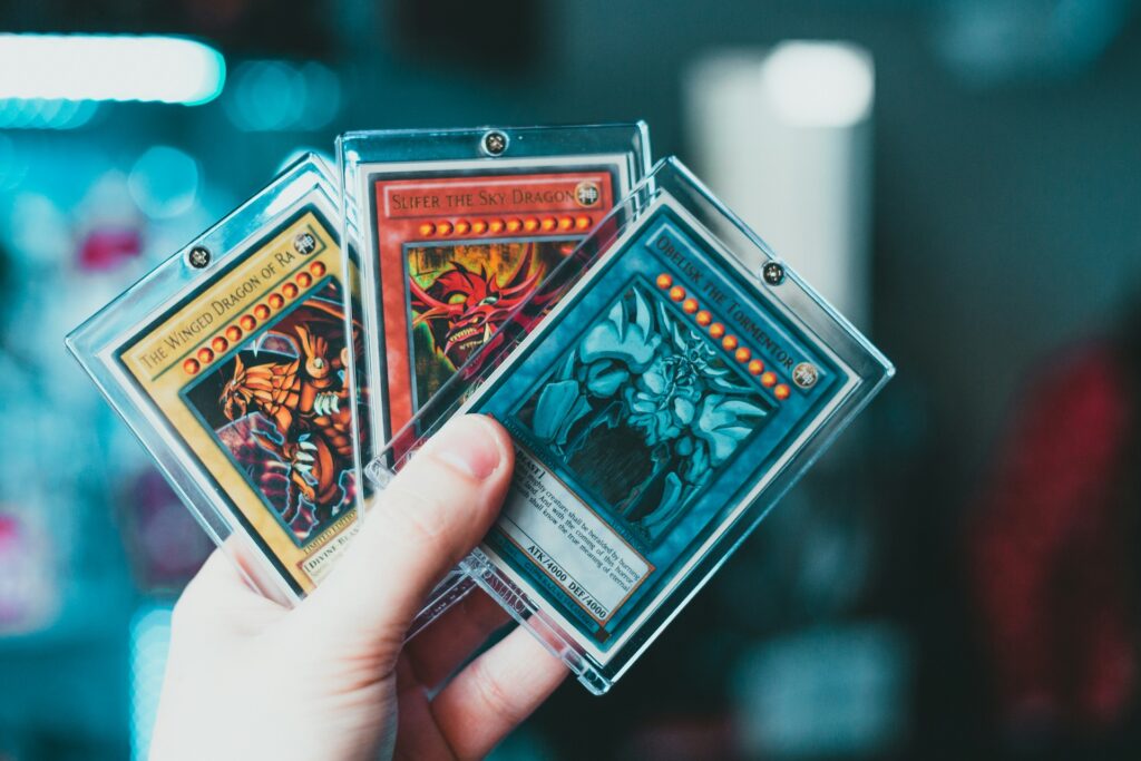 Drei Yu-Gi-Oh Karten in der Hand einer Person